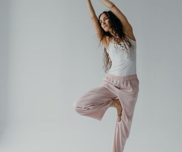 Person stretching gracefully in a bright, peaceful studio.