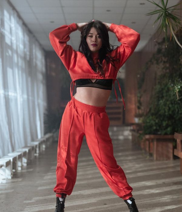 Woman in a graceful yoga pose with a flowing red energy effect.